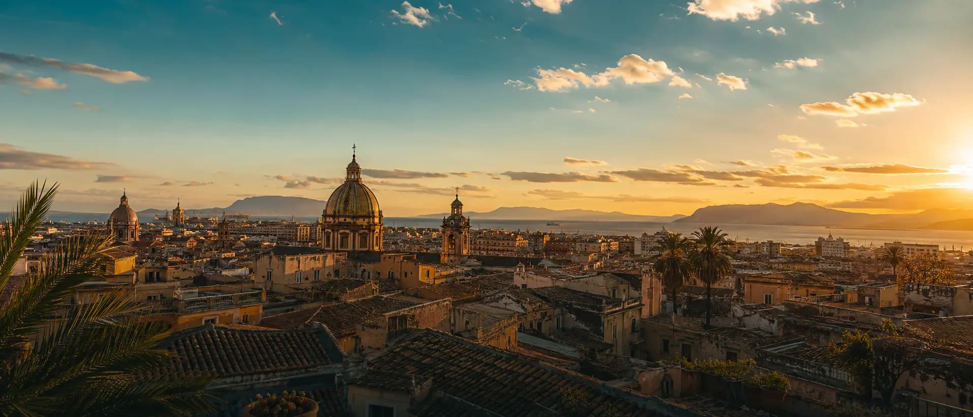 Golden-hour view across the rooftops and domes of Palermo's historic centre
